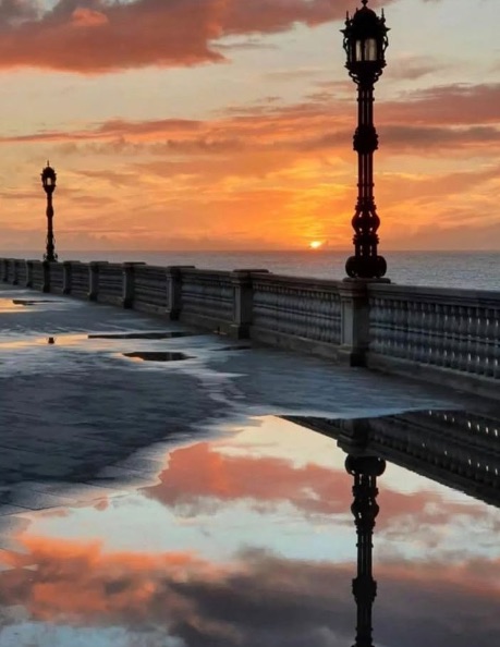 Espectacular atardecer con reflejos en el suelo en el paseo costero de la Alameda en Cádiz - Vistas al mar exclusivas Engel & Völkers.